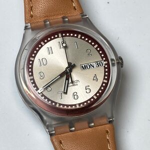 Swatch watch, tan strap, new battery plus spare battery